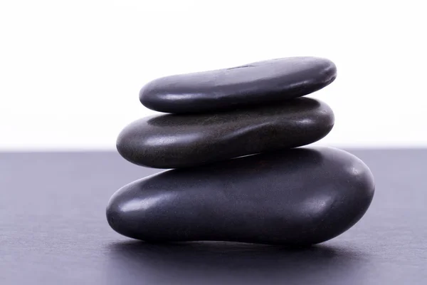 Tres piedras de masaje negro equilibrado —  Fotos de Stock