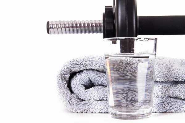 Glas water, zwarte barbell en handdoek — Stockfoto