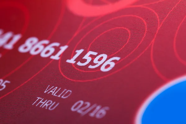 Красная кредитная карта с номерами — стоковое фото
