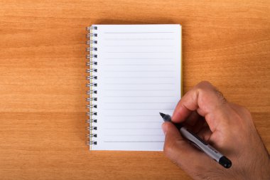 elini tutarak Kalem defter üzerinde