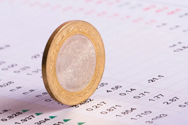 Монета, стоящая на финансовых данных — стоковое фото