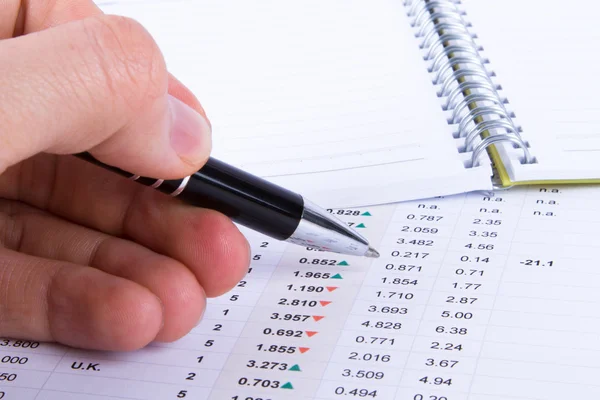 Ręka trzyma długopis i analizy danych finansowych — Zdjęcie stockowe