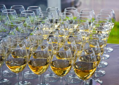 İnce saplı bir tepside duran çok sayıda parlak cam bardak.