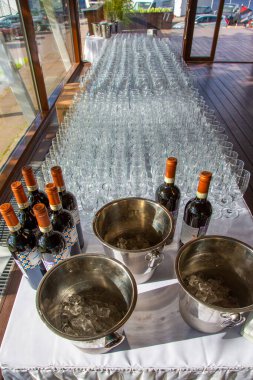 İnce saplı bir tepside duran çok sayıda parlak cam bardak.