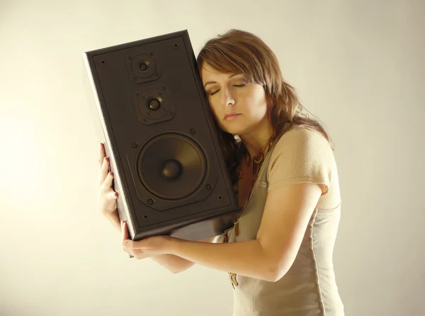 Beautiful woman holding big wooden speaker — Stock Photo, Image