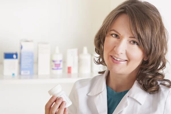 Giovane farmacista donna con una bottiglia di farmaci — Foto Stock