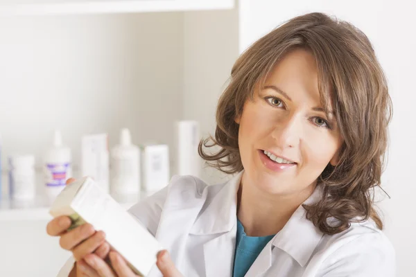 Young woman pharmacist with a bottle of drugs — Stock Photo, Image