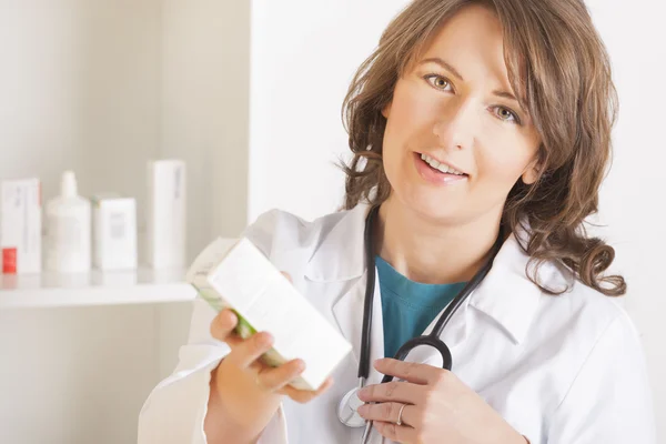 Young woman pharmacist or doctor with a bottle of drugs — Stock Photo, Image