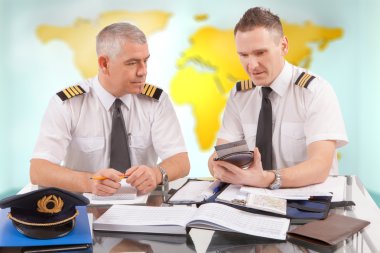Airline pilots filling in papers in ARO clipart