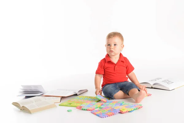 Kid met veel boeken en brief puzzels — Stockfoto
