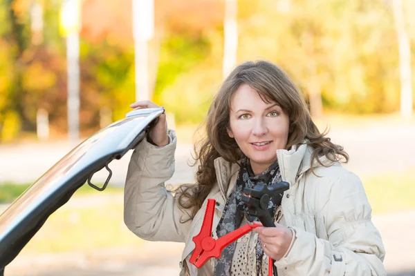 Vrouw booster kabels aansluiten — Stockfoto