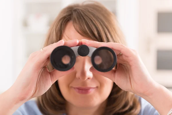 Woman looking through binocular — Stock Photo, Image