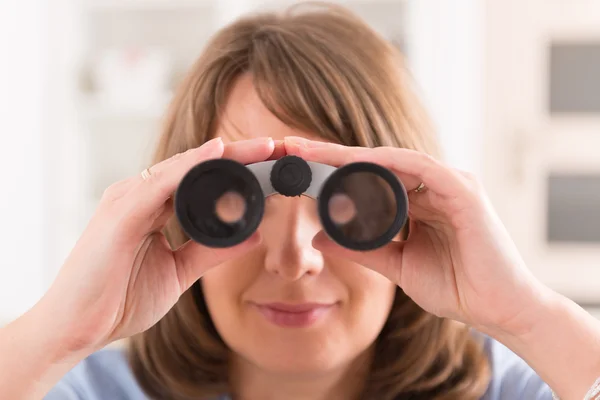 Frau blickt durch Fernglas — Stockfoto