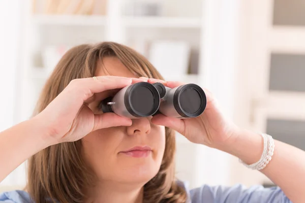 Frau blickt durch Fernglas — Stockfoto