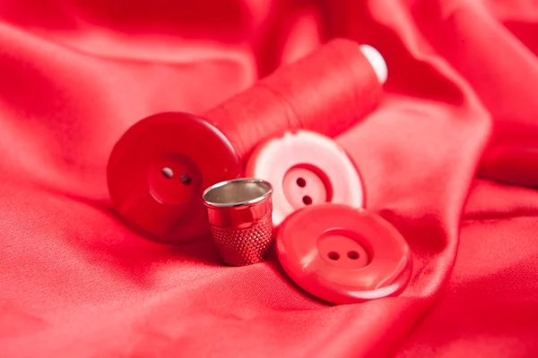 Tejido rojo y accesorios de costura — Foto de Stock