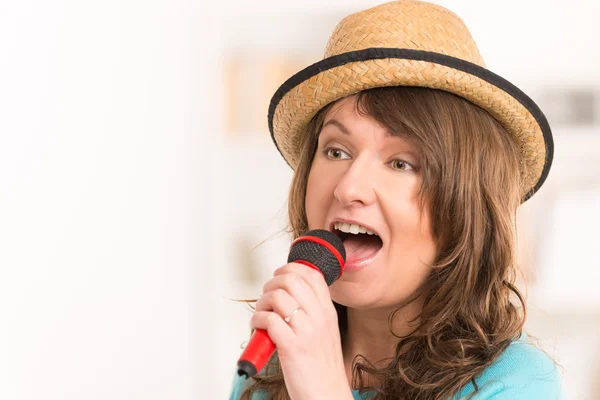 Mulher cantando com um microfone — Fotografia de Stock