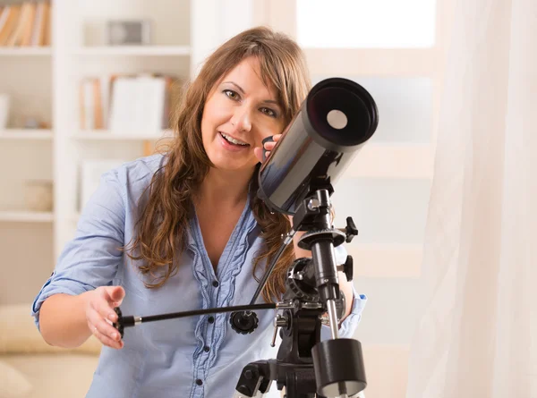 Schöne Frau blickt durch Teleskop — Stockfoto