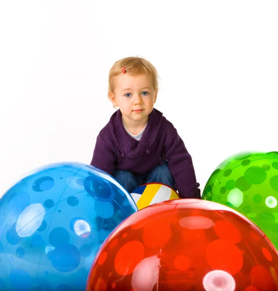 Schattige babymeisje en ballen — Stockfoto