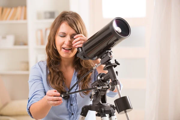 Красивая женщина смотрит в телескоп — стоковое фото