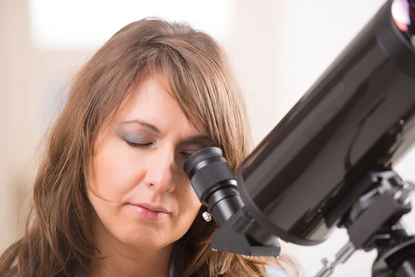 Beautiful woman looking through telescope — Stock Photo, Image