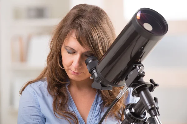 Hermosa mujer mirando a través del telescopio — Foto de Stock