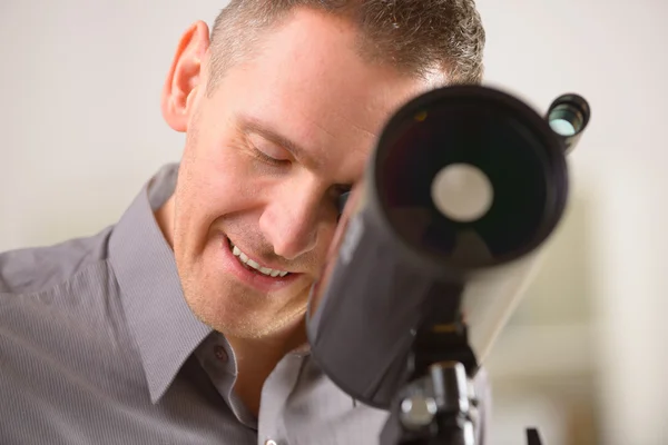 Homem olhando através do telescópio — Fotografia de Stock