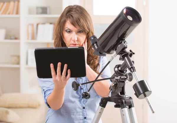 Schöne Frau mit Teleskop und Tablet — Stockfoto