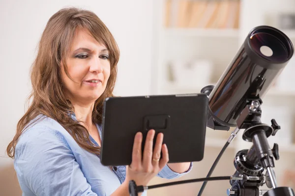 Piękna kobieta z teleskopu i tabletki — Stockfoto