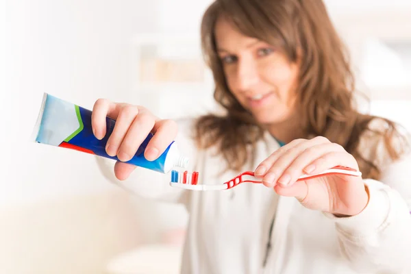 Mujer sosteniendo cepillo de dientes y pasta de dientes —  Fotos de Stock