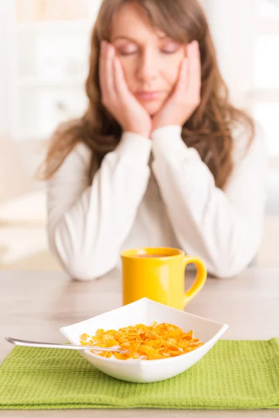 Schläfrige Frau frühstückt zu Hause — Stockfoto