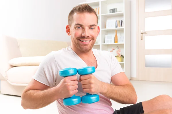 Handsome man holding dumb bells — Stock Photo, Image