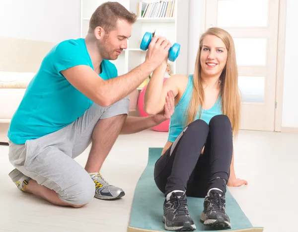 Mulher com personal trainer em casa — Fotografia de Stock