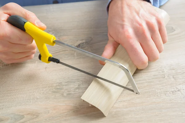 Cutting plastic molding met handzaag — Stockfoto