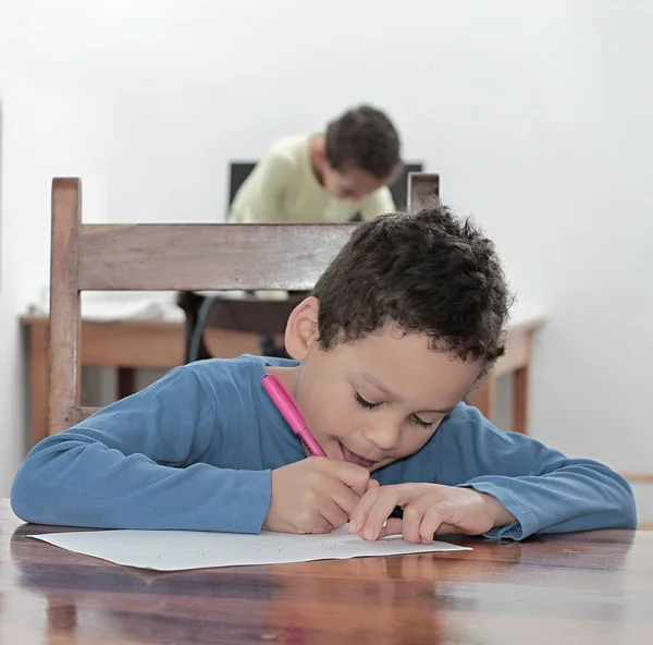 Niño Escribiendo Papel Mientras Está Sentado Mesa Aula Fotos Stock — Foto de Stock