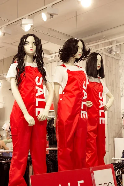 Maniquíes femeninos en mazmorras rojas en tienda de ropa de moda, negro viernes venta concepto de compras, oferta de temporada promo — Foto de Stock