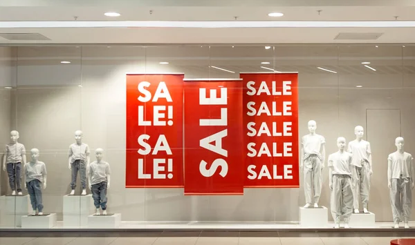 Segno di vendita su banner rossi con manichini in vetrina del negozio di moda, venerdì nero in vetrina promozionale Foto Stock