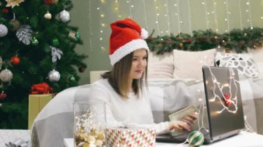 Bilgisayarlı Noel Baba şapkalı kadın evde konuşur, güler geçerdi. İnternetten alışveriş yapar ya da Noel 'de ödeme yapardı.
