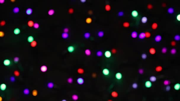 Dovolená pozadí vánoční dekorativní barevné věnce na černém pozadí, slavnostní blikání vánočních světel — Stock video