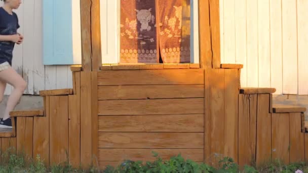 Femme monter les escaliers sur le vieux porche de la maison de campagne, porte ouverte de la cabine en banlieue — Video