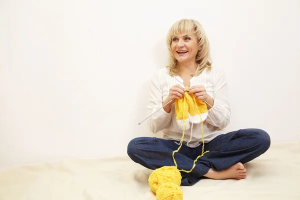 Sitzende Frau strickt — Stockfoto