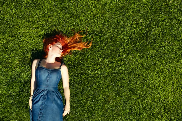 Çimenlerin üzerinde kırmızı saçlı kız — Stok fotoğraf