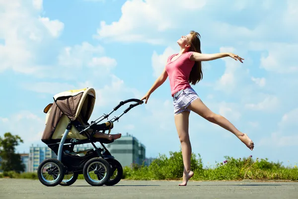 Ung mor med barnvagn — Stockfoto