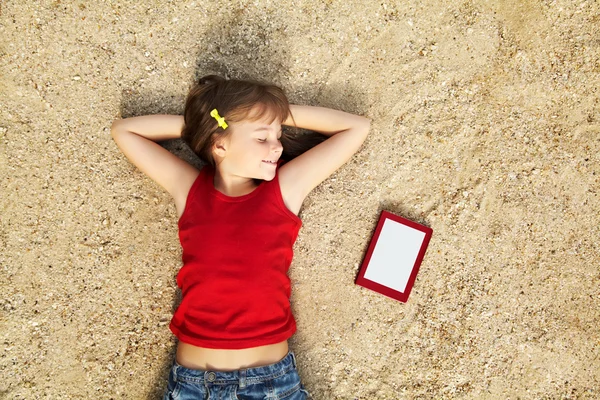 Jente som ligger i sanden – stockfoto