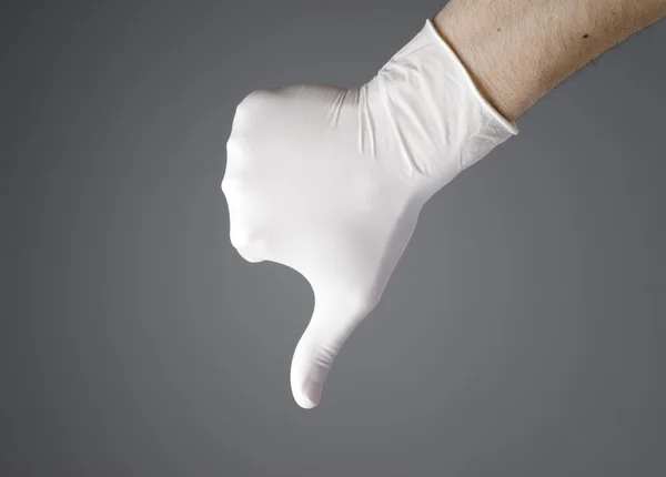 Mão com uma luva de látex expressando negatividade — Fotografia de Stock