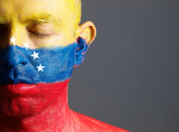 Homem e seu rosto pintado com a bandeira da Venezuela e fechado e — Fotografia de Stock