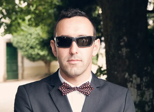 蝶ネクタイとサングラスを持つ男の肖像 — ストック写真