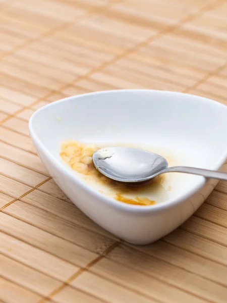 Een bowl en een lepel overblijfselen van pudding — Stockfoto