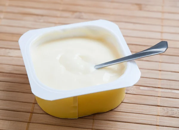 Custard and spoon inside — Stock Photo, Image