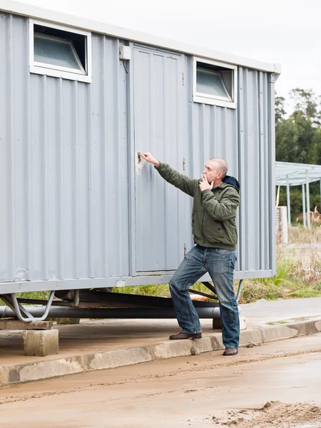 Hombre abriendo una cabaña sitio — Foto de Stock