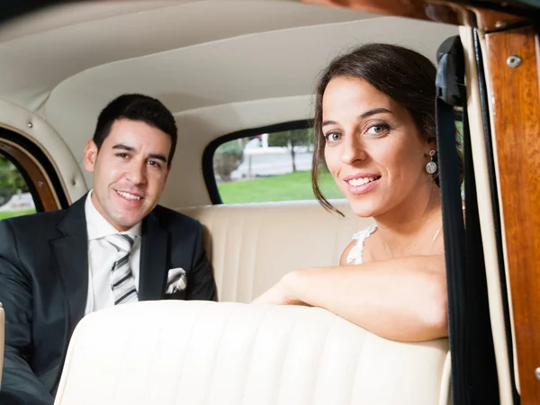 Жених и невеста в классическом автомобиле — стоковое фото